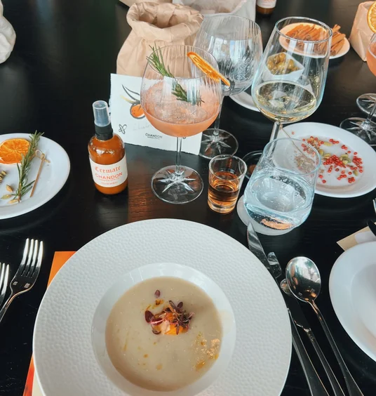 Chandon drinks, table setting and plated soup with orange and rosemary garnishes