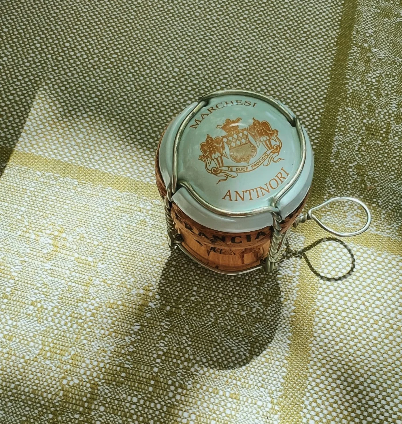 Antinori-branded champagne-style cork and wire cage on a checked cloth