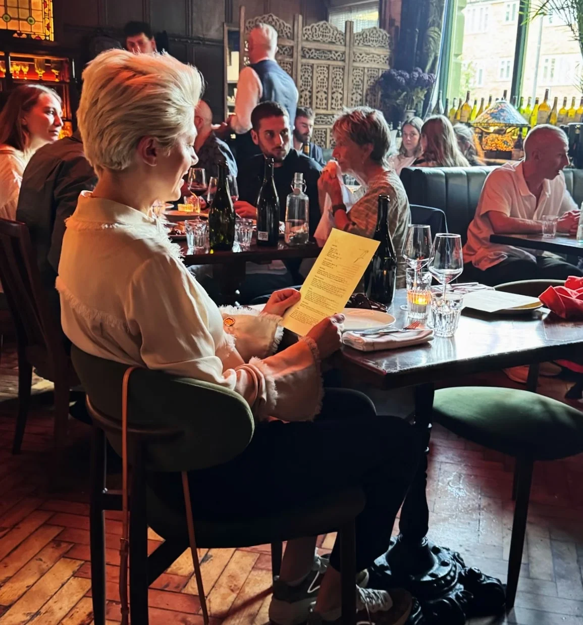 People dining with wine and menus in a characterful restaurant