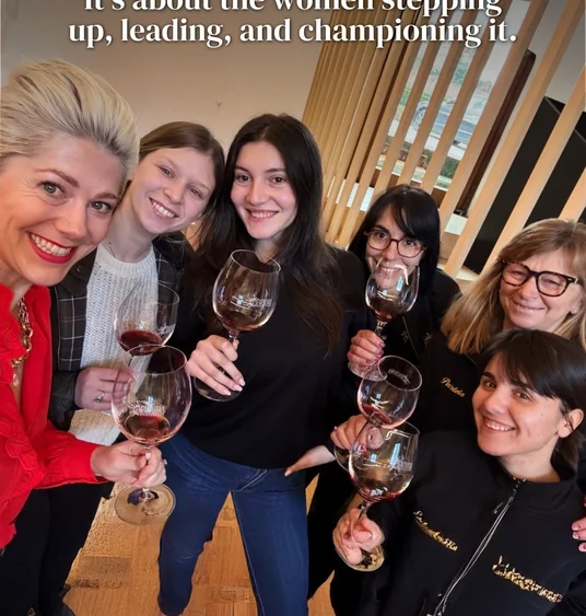 Group of women smiling and holding wine glasses beneath text about women leading and championing wine