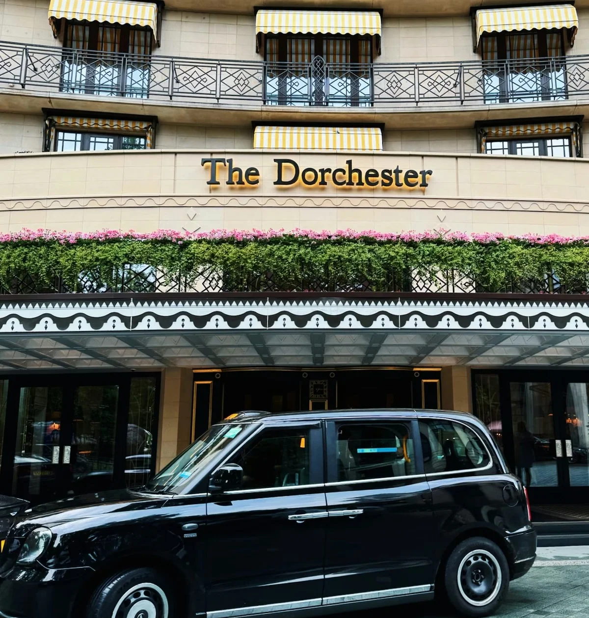 The Dorchester hotel entrance with a black taxi in front