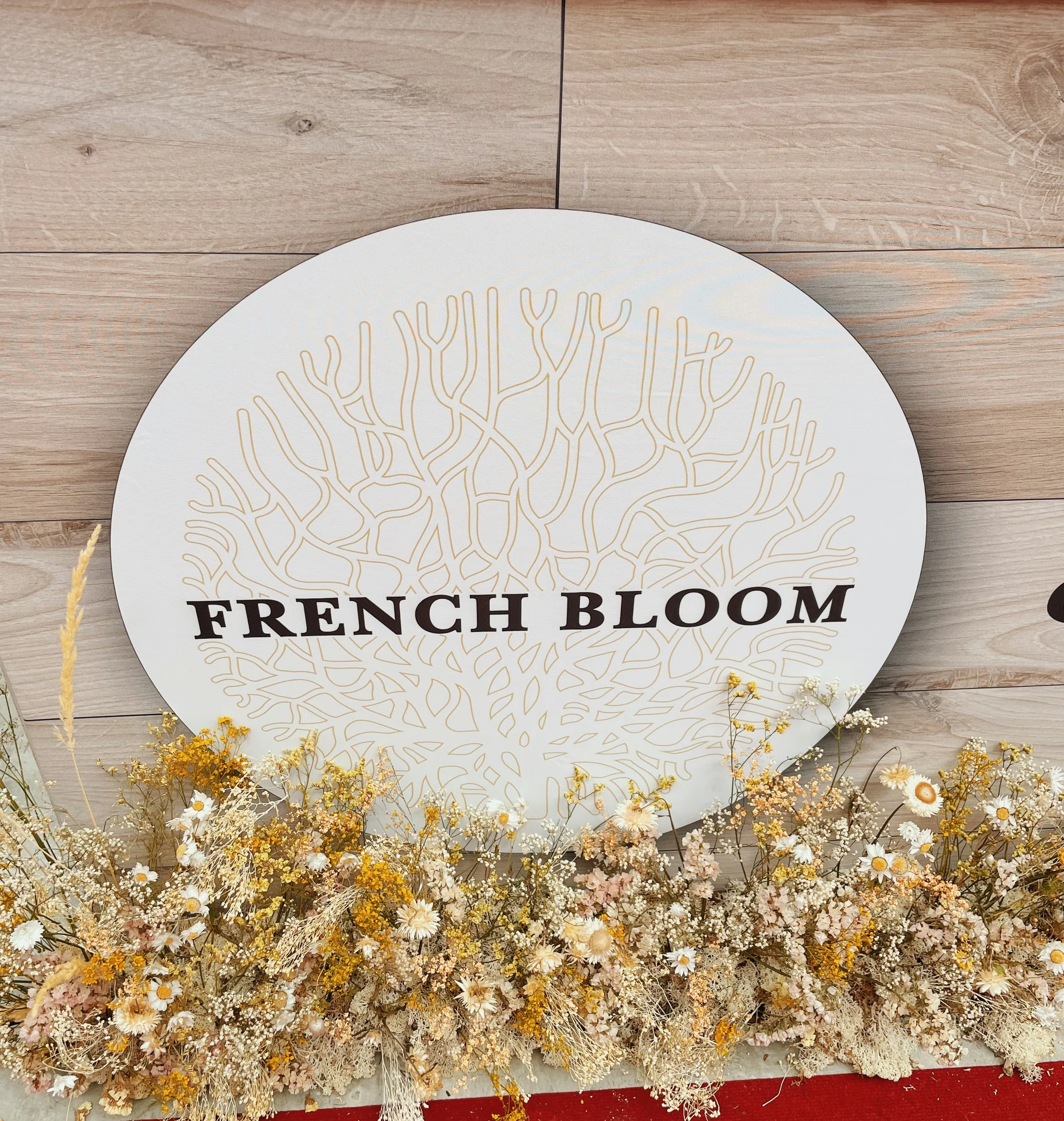 French Bloom sign with dried flowers in front of a bar
