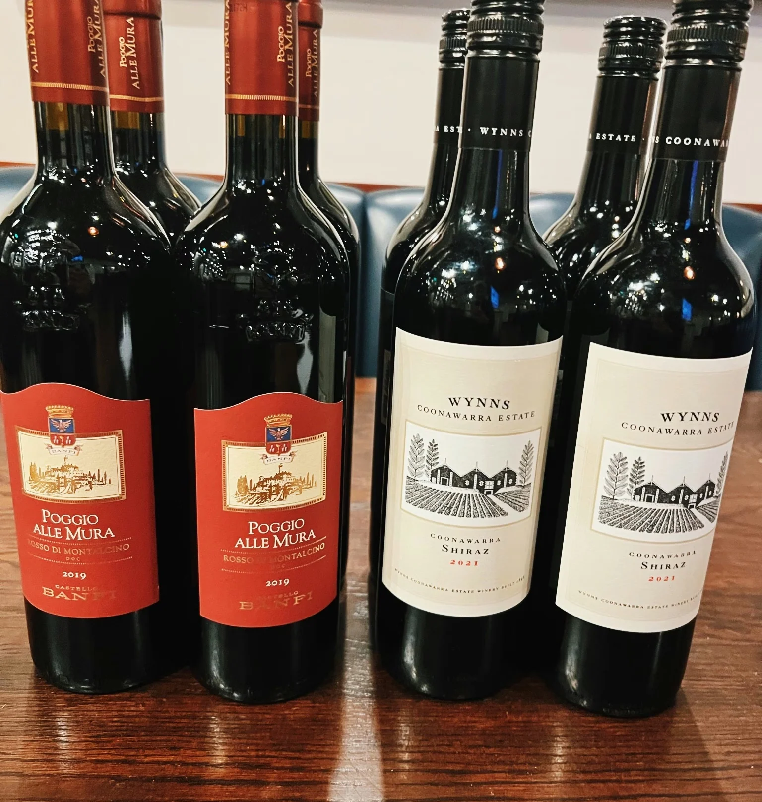 Four red wine bottles, including Poggio alle Mura Brunello and Wynns Coonawarra Estate Shiraz