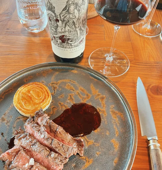 Steak served with pastry and red wine at a tasting table