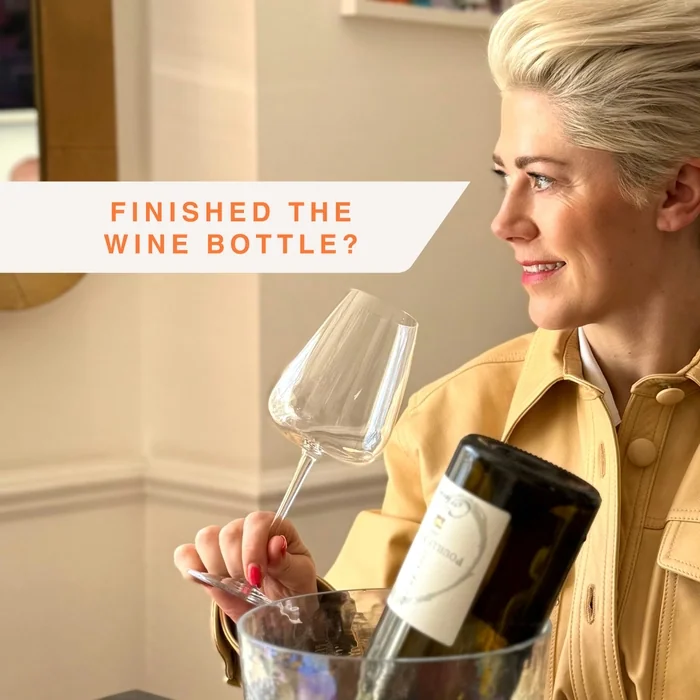 Woman holding wine glass and bottle, with Finished the wine bottle text