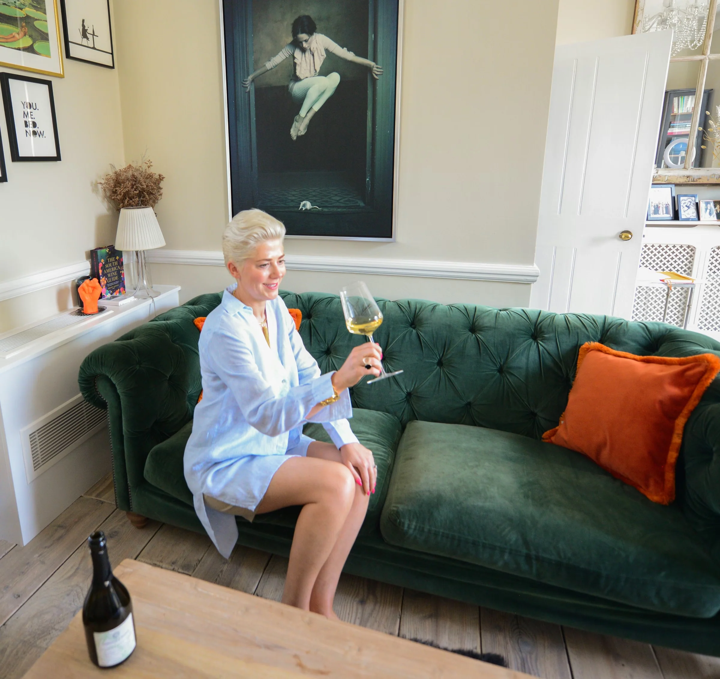 Elizabeth Hawthornthwaite holds a glass beside a bottle of non-alcoholic sparkling tea in her sitting room