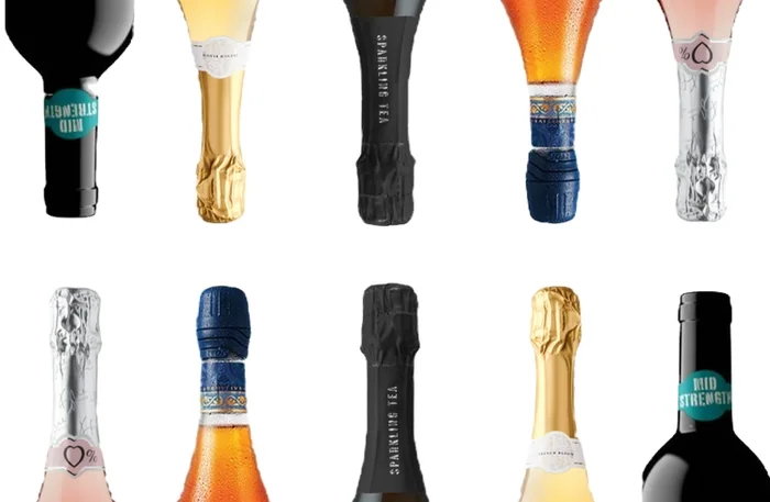 Assorted sparkling wine bottles with colourful foils on white background