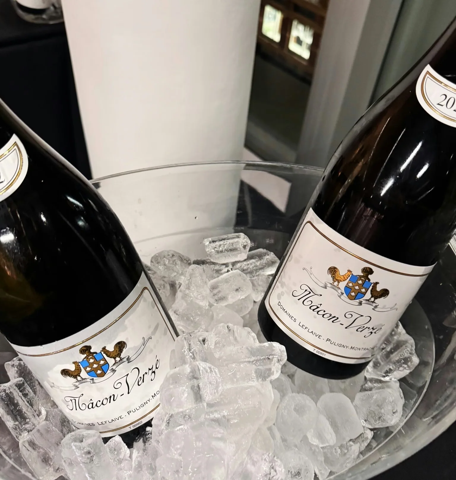 Two bottles of Mâcon-Verzé wine chilling in an ice bucket at a tasting event