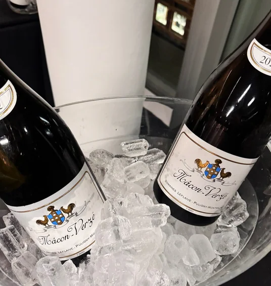 Two bottles of Mâcon-Verzé wine chilling in an ice bucket at a tasting event