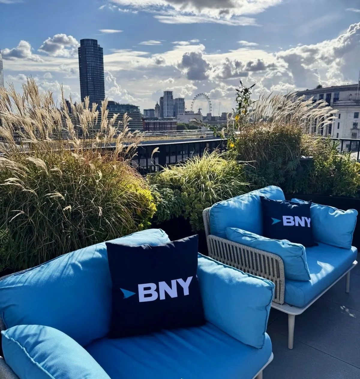 Blue BNY seating on a planted rooftop terrace overlooking the London Eye