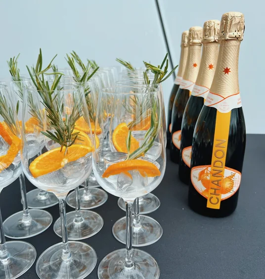 Chandon Garden Spritz bottles beside glasses garnished with orange and rosemary