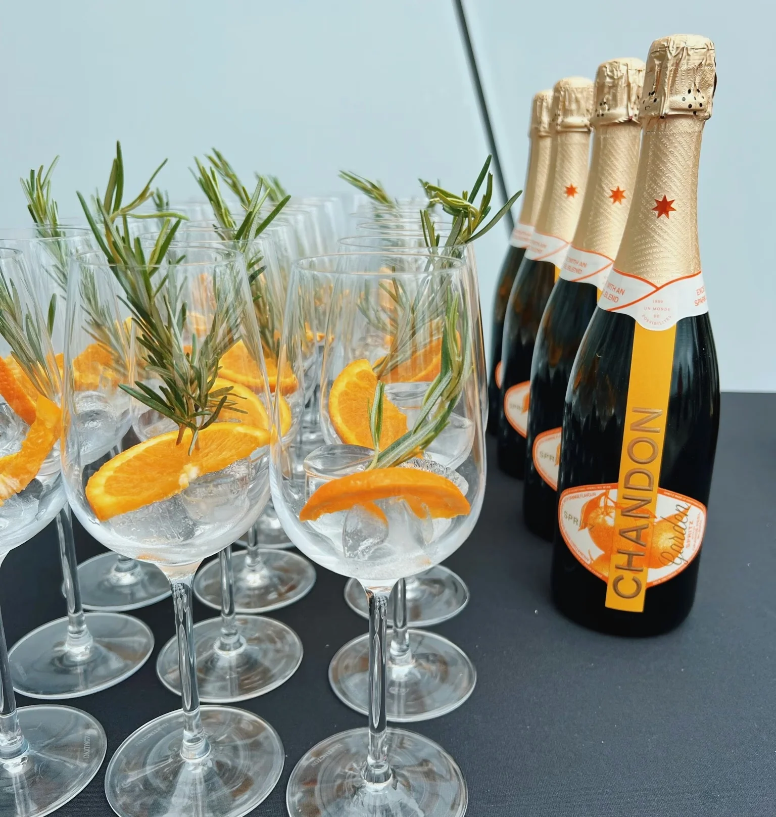 Chandon Garden Spritz bottles beside glasses garnished with orange and rosemary