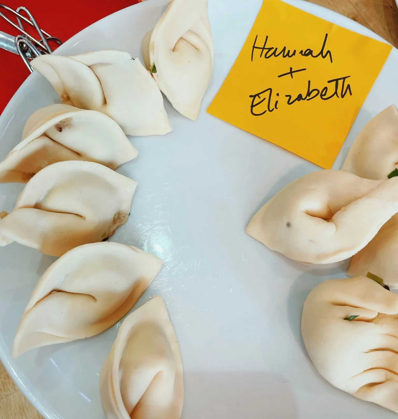 Plate of dumplings with a handwritten card reading “Hannah + Elizabeth”