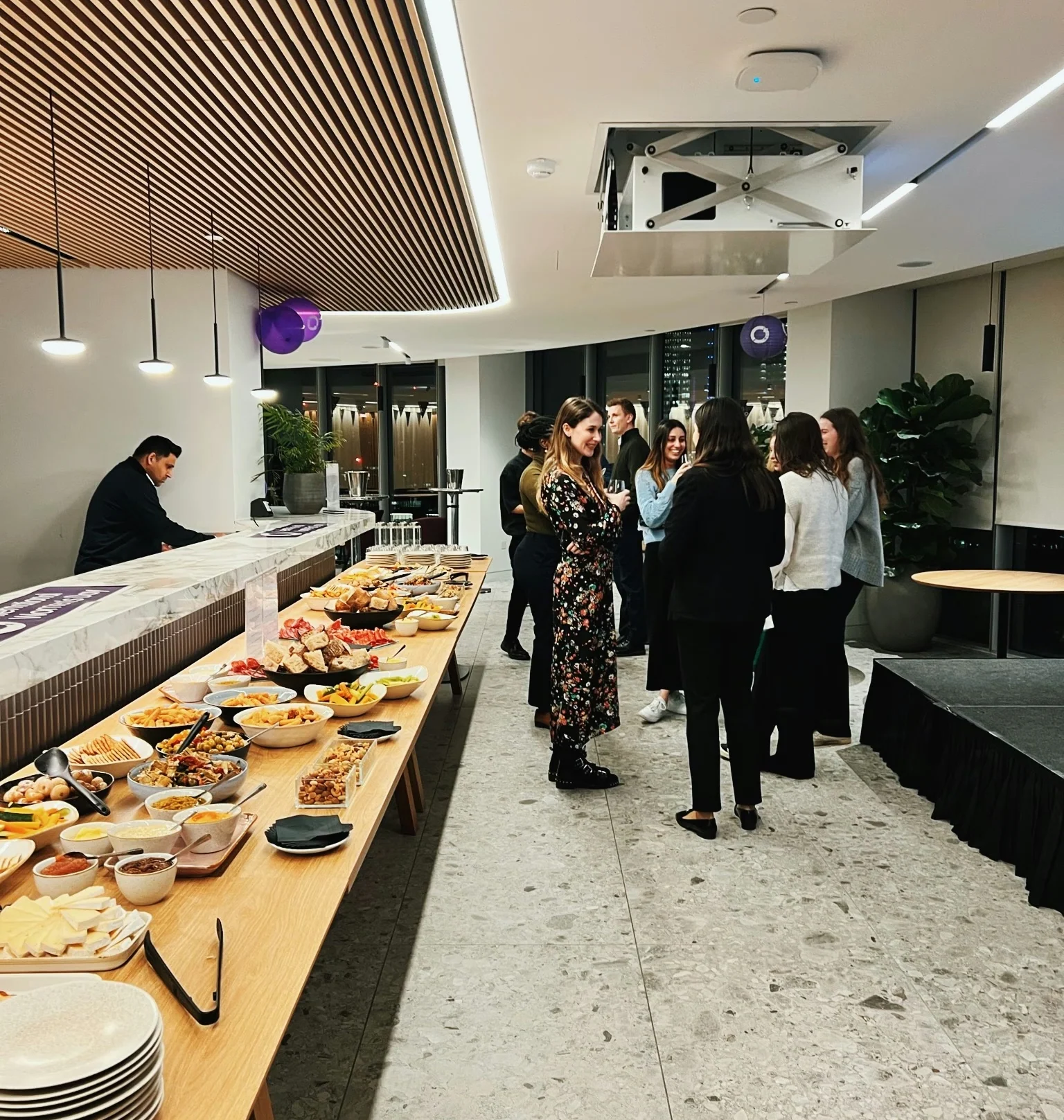 Guests mingle beside a buffet in a modern London event space