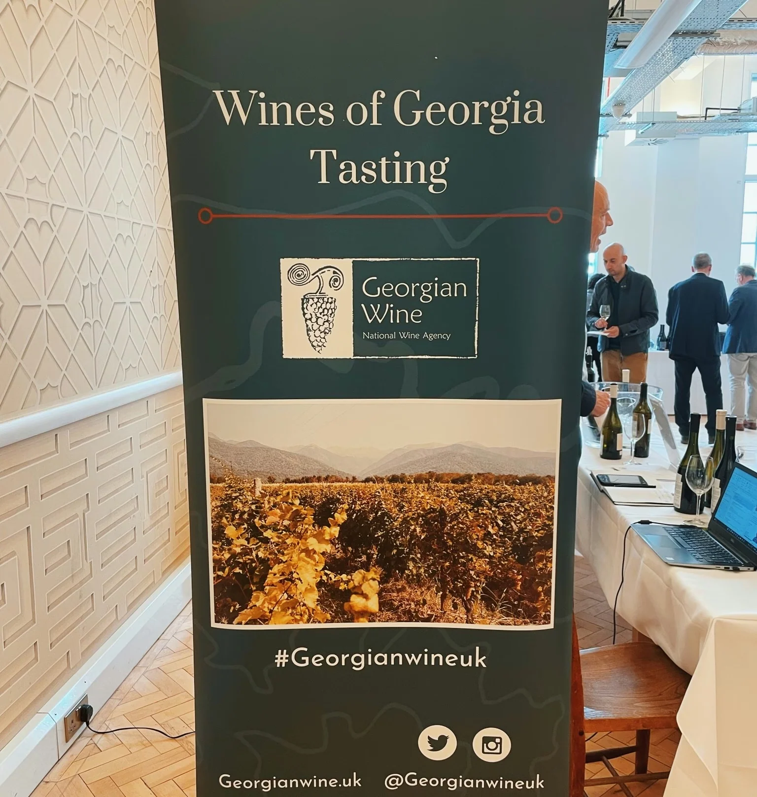 Banner for a Wines of Georgia tasting beside a table of wine bottles and glasses