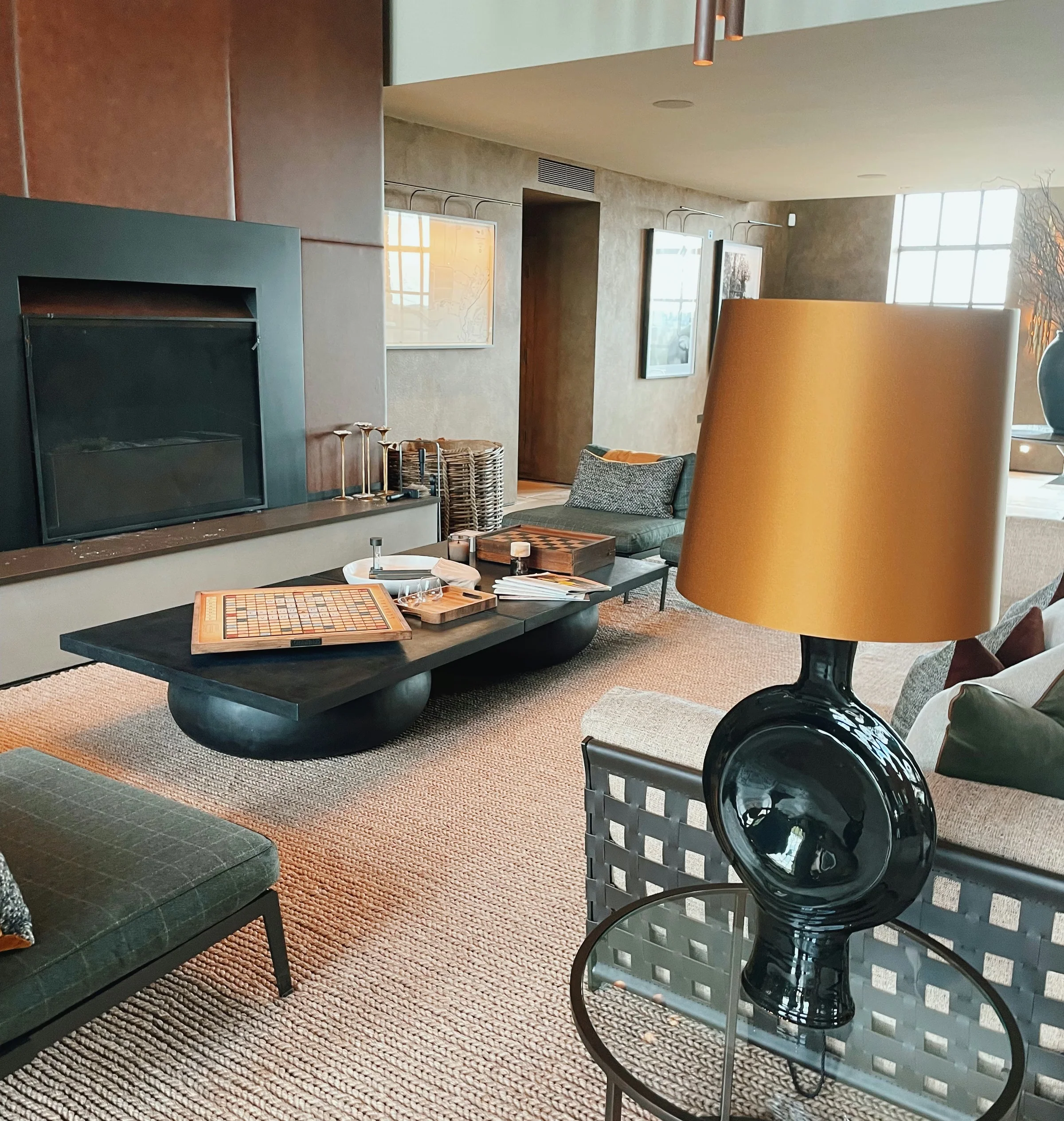 Exton Park tasting room lounge with fireplace, seating, games and a bottle-shaped table lamp