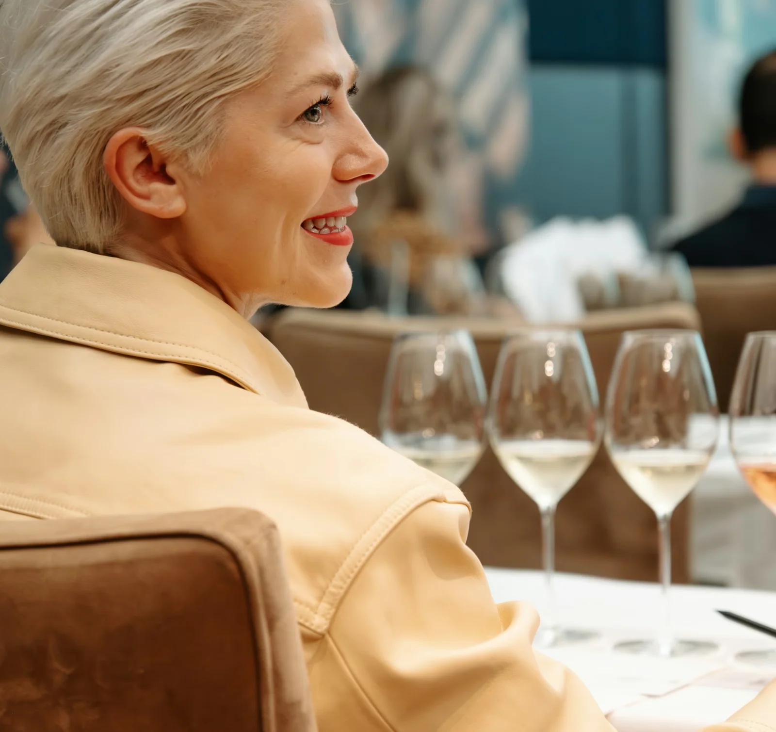 Guests seated at a wine tasting table with glasses of white and rosé wine