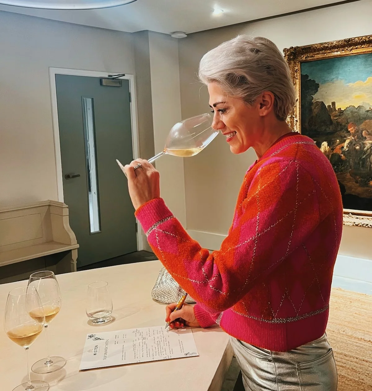Woman tasting English wine and writing notes at a Wiston tasting table