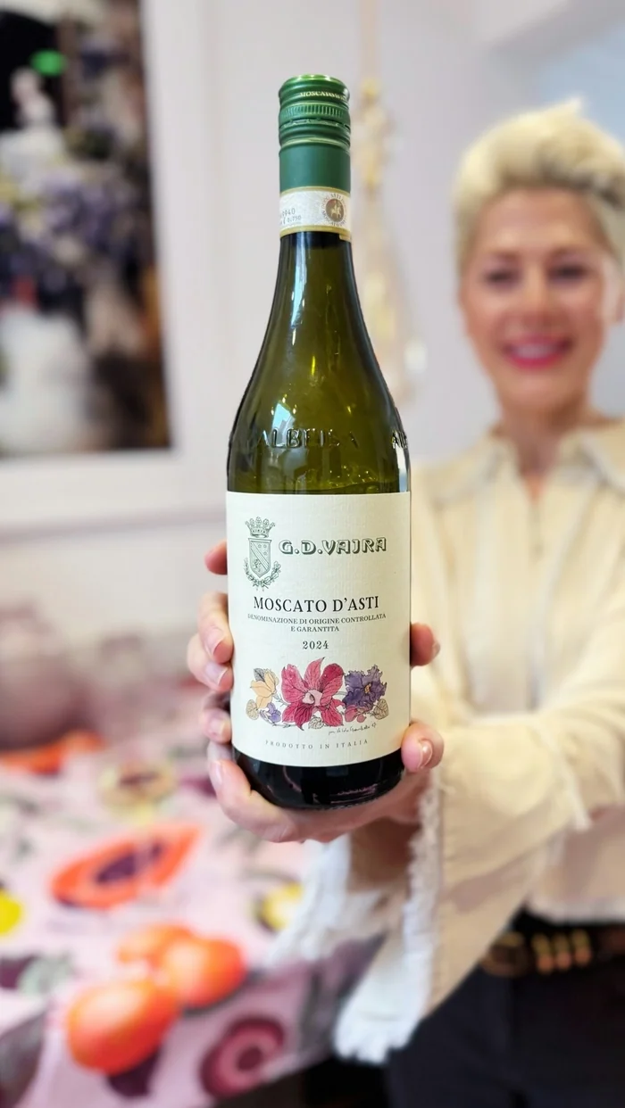 Woman holding bottle of G.D. Vajra Moscato d’Asti wine