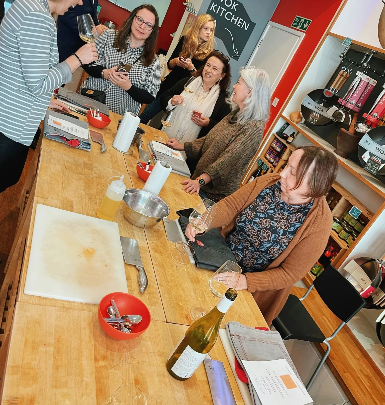 Guests tasting white wine around a kitchen island during a group event