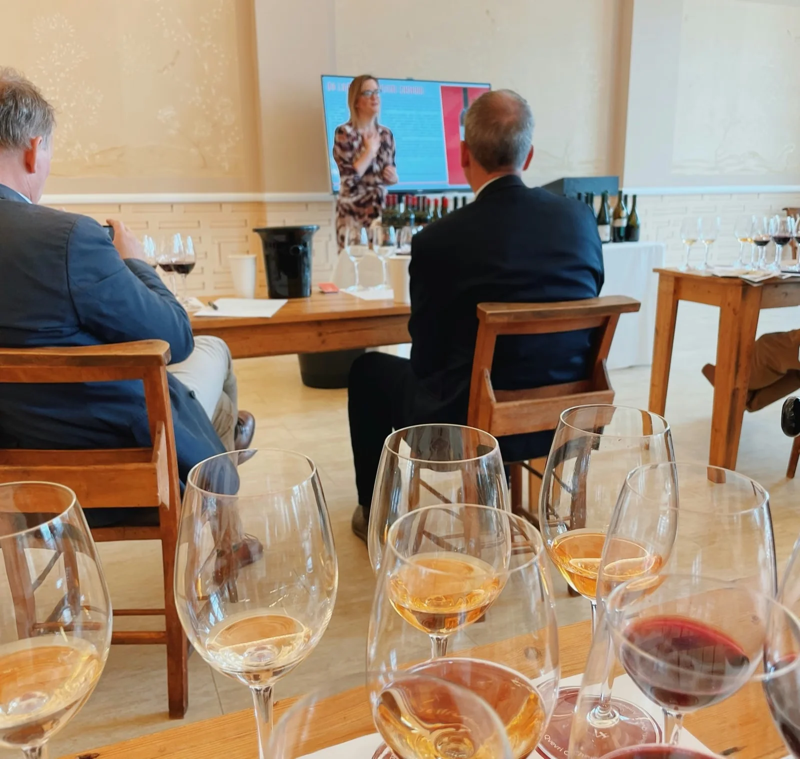 Wine tasting with several glasses in the foreground and a presentation on screen