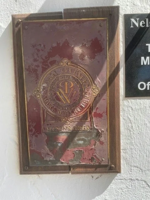 Worn vintage wine plaque on white wall