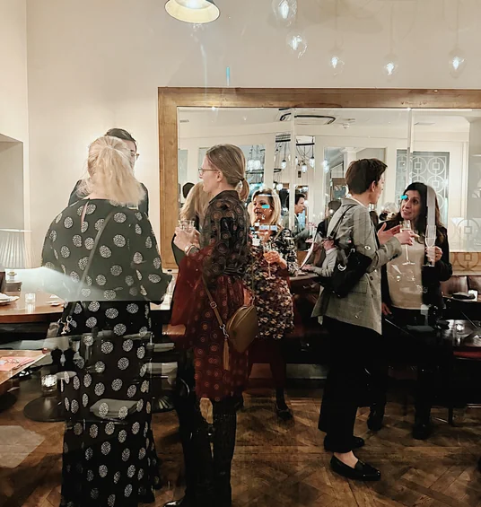 Guests mingle with wine glasses in an elegant restaurant dining room