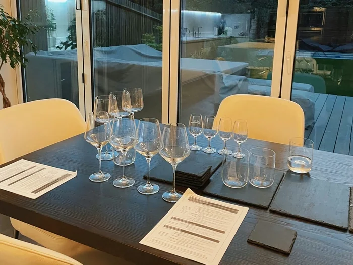 Wine glasses and tasting sheets on a dining table indoors