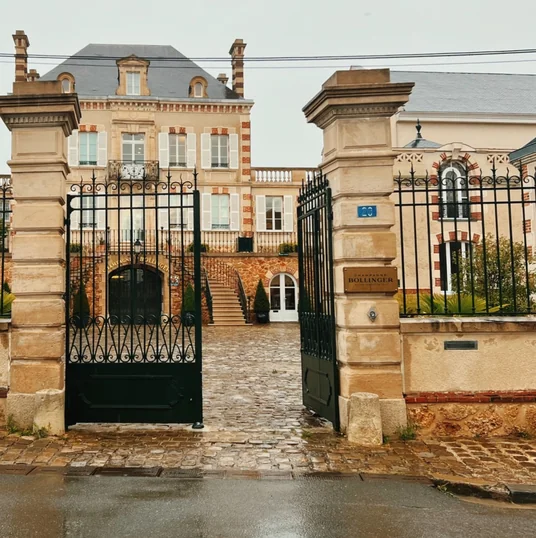 Entrance to Champagne Bollinger, with ornate gates and a grand building at number 20.