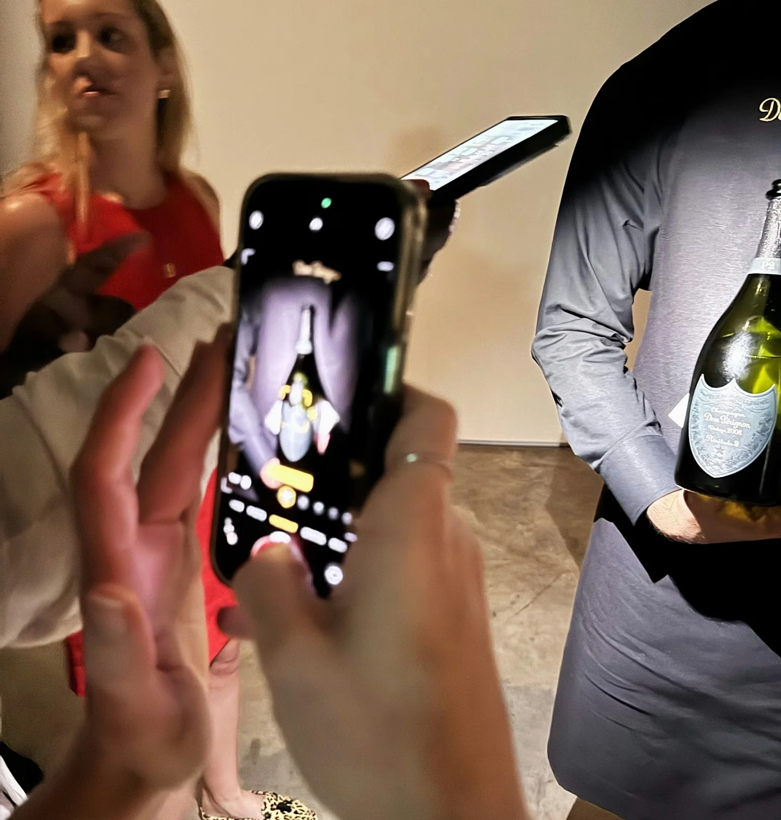 Guest photographs a Dom Pérignon bottle during a wine tasting