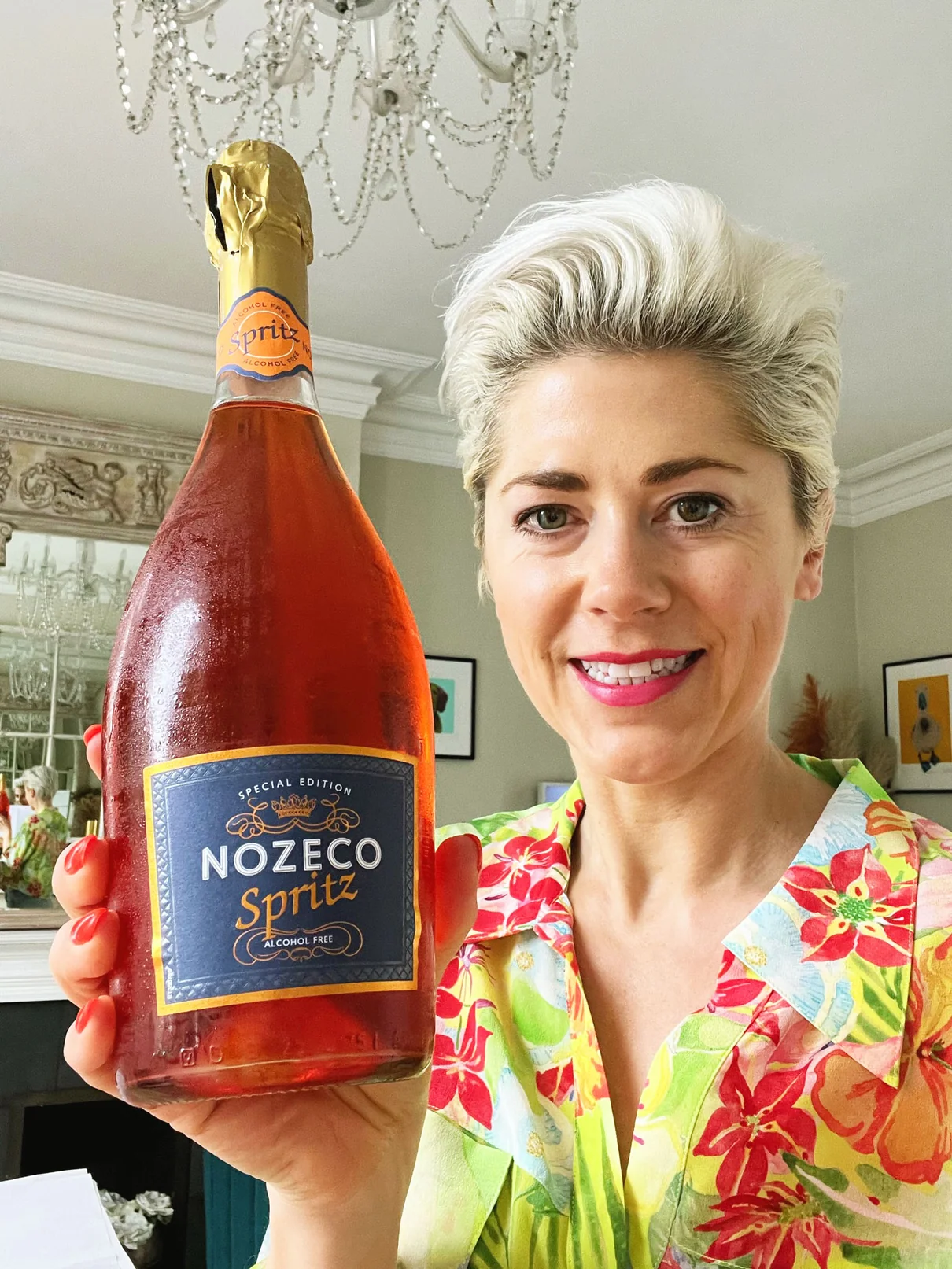 Woman holding Nozeco Spritz bottle in elegant room