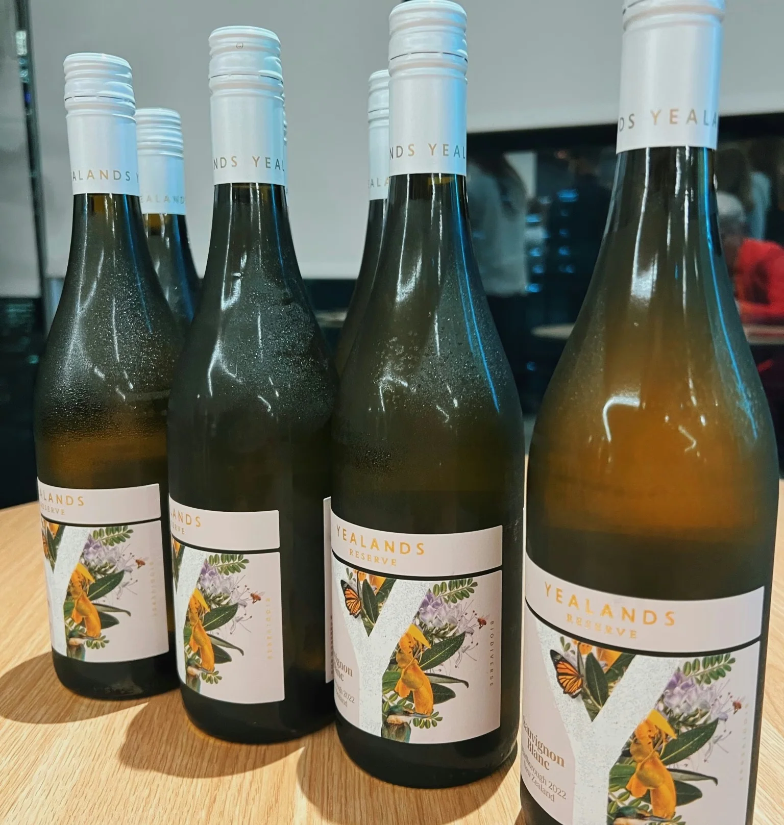Four Yealands wine bottles arranged on a wooden table