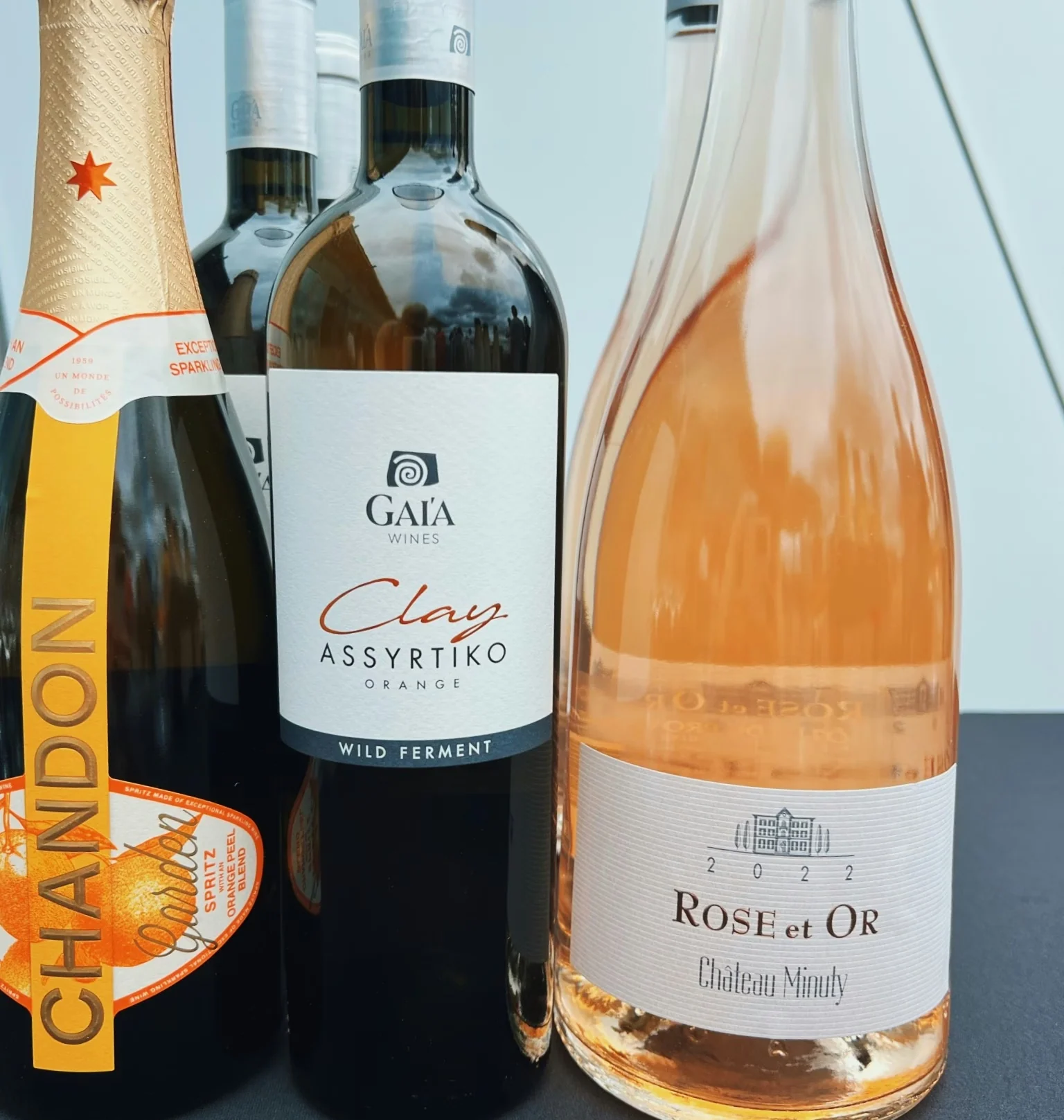 Close-up of sparkling, orange and rosé wine bottles arranged together