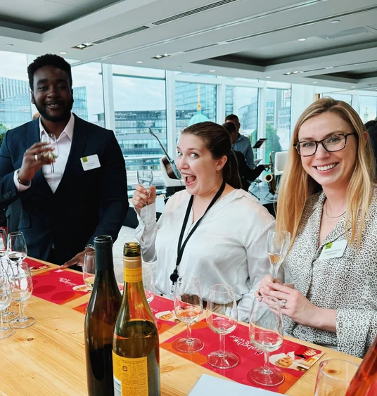 Guests raise wine glasses at a corporate tasting in a bright London venue