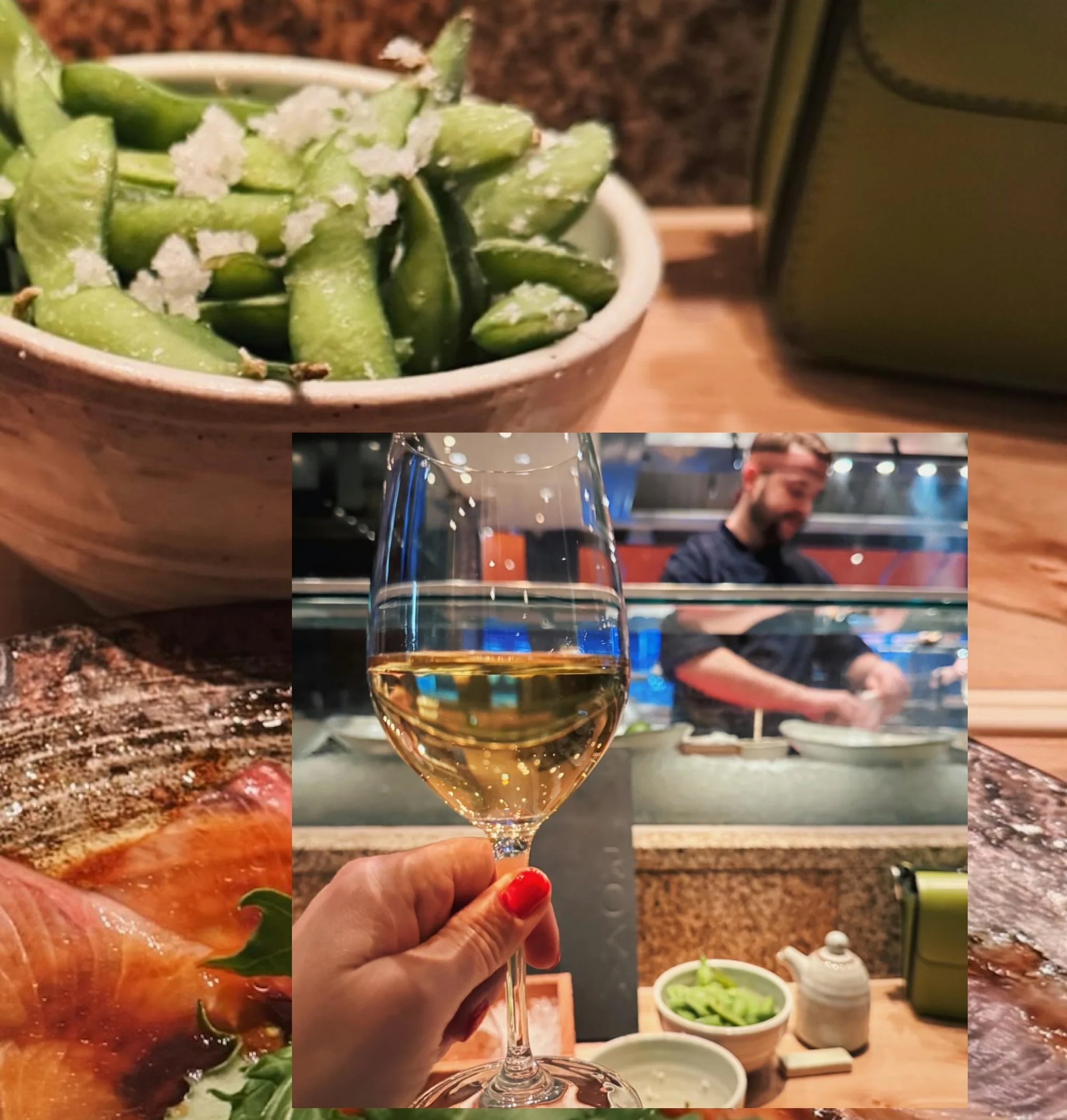Hand holding a glass of white wine beside a bowl of salted green beans in a restaurant