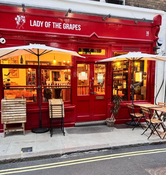 Red Lady of the Grapes wine bar frontage with outdoor tables and umbrellas
