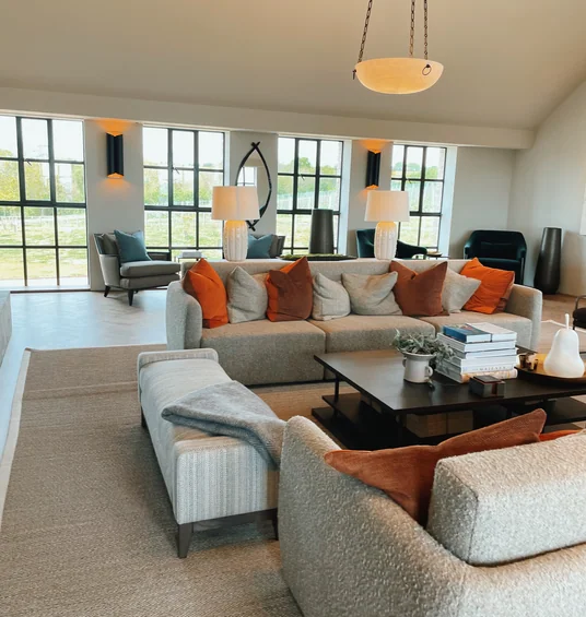 Bright Exton Park tasting room lounge with sofas, armchairs, lamps, coffee table and vineyard views
