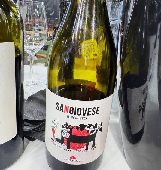 Bottle of Sangiovese Il Pometo wine by Lungarotti displayed between other bottles at Wine Paris