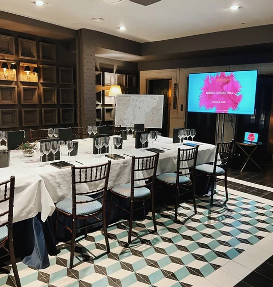 Wine tasting room set with glasses, a presentation screen and a Bodega Numanthia map