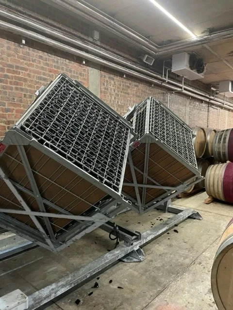 Wine racks in a cellar beside stacked oak barrels