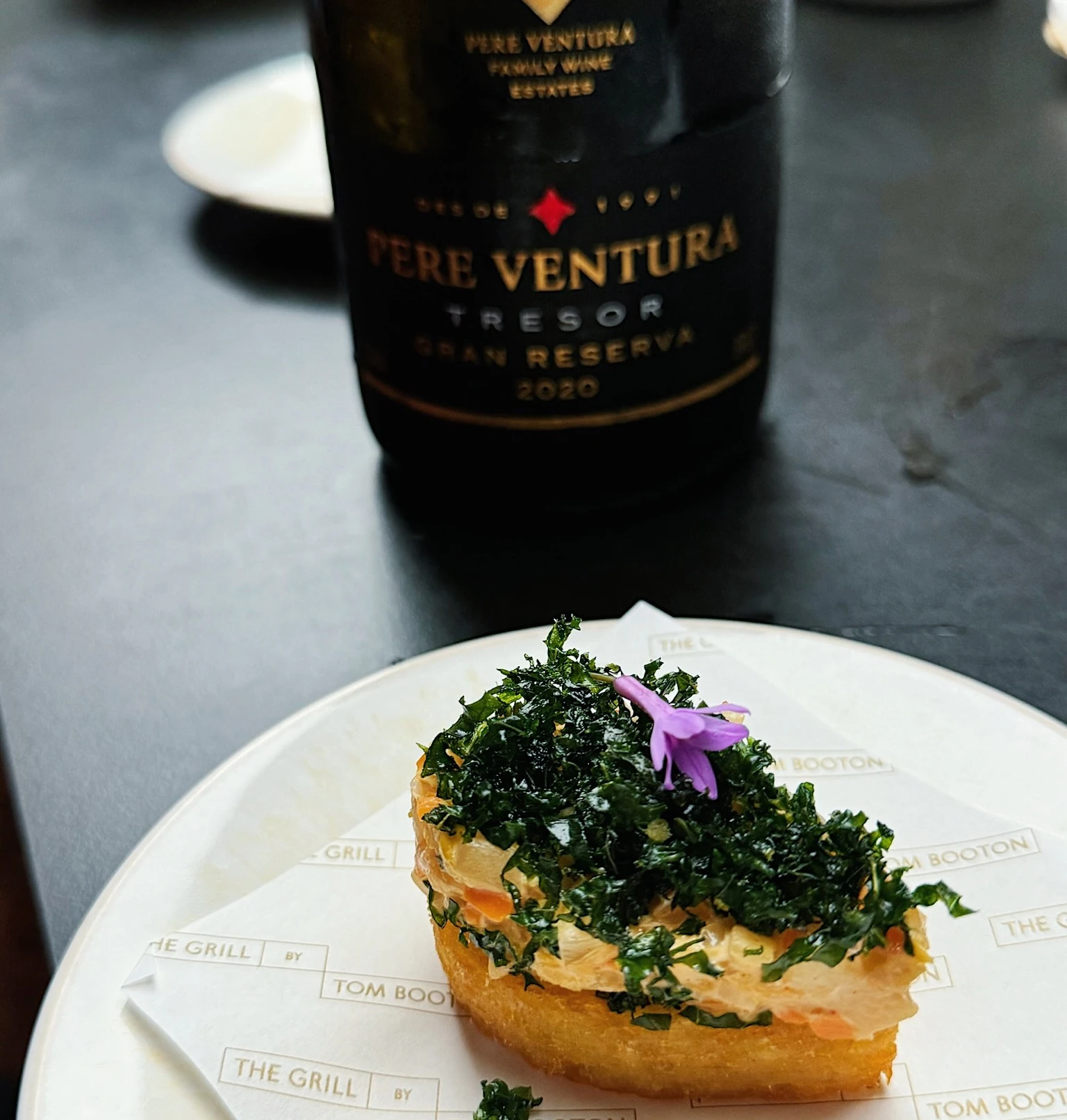 Tom Booton canapé with kale garnish beside a Pere Ventura Tresor Gran Reserva 2020 bottle
