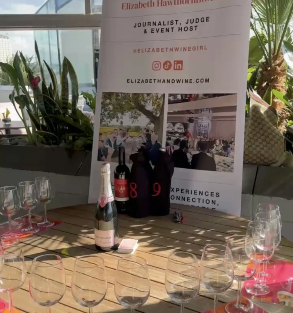 Blind wine tasting table with glasses, bottles and Elizabeth & Wine event banner