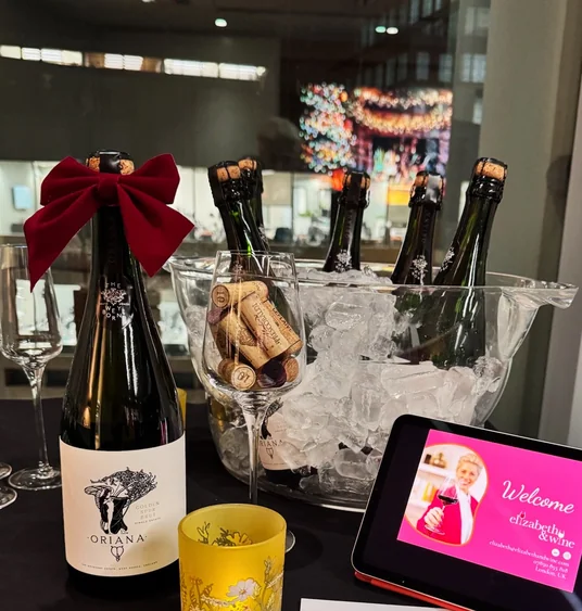 Bottles of Oriana sparkling wine in an ice bucket, with a welcome tablet and tasting glasses