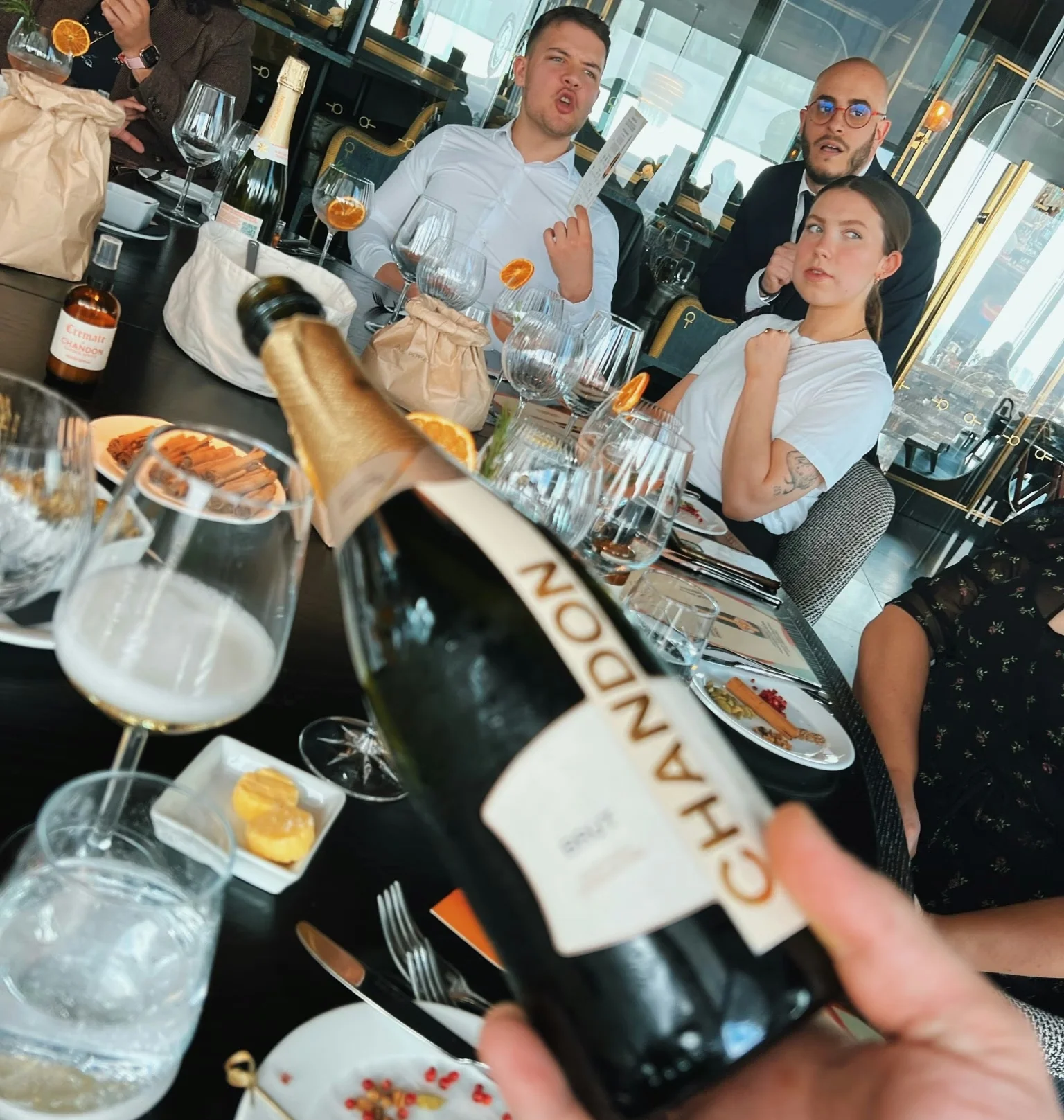Guests enjoy a Chandon wine tasting with glasses, snacks and bottles around a restaurant table