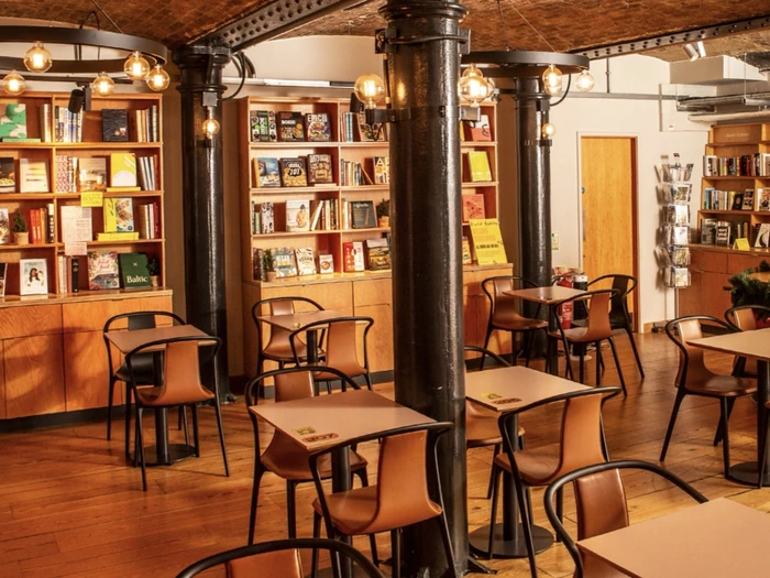 Cosy bookshop café with tables, chairs and bookshelves