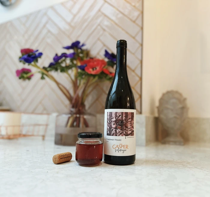 Wine bottle, small jar and cork on kitchen counter