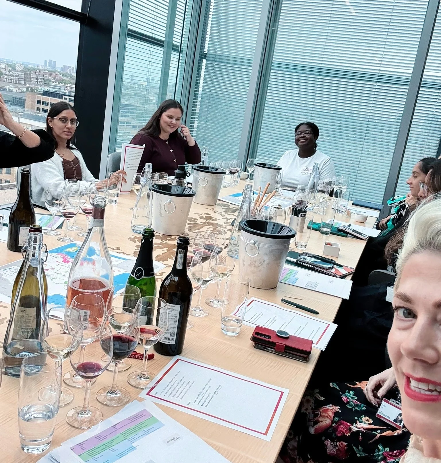 Corporate wine tasting around a table with wine glasses, bottles and tasting notes