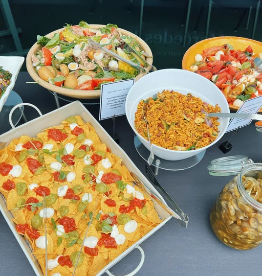 Buffet table with salads, nachos, rice and pickled vegetables at Mercedes-Benz World