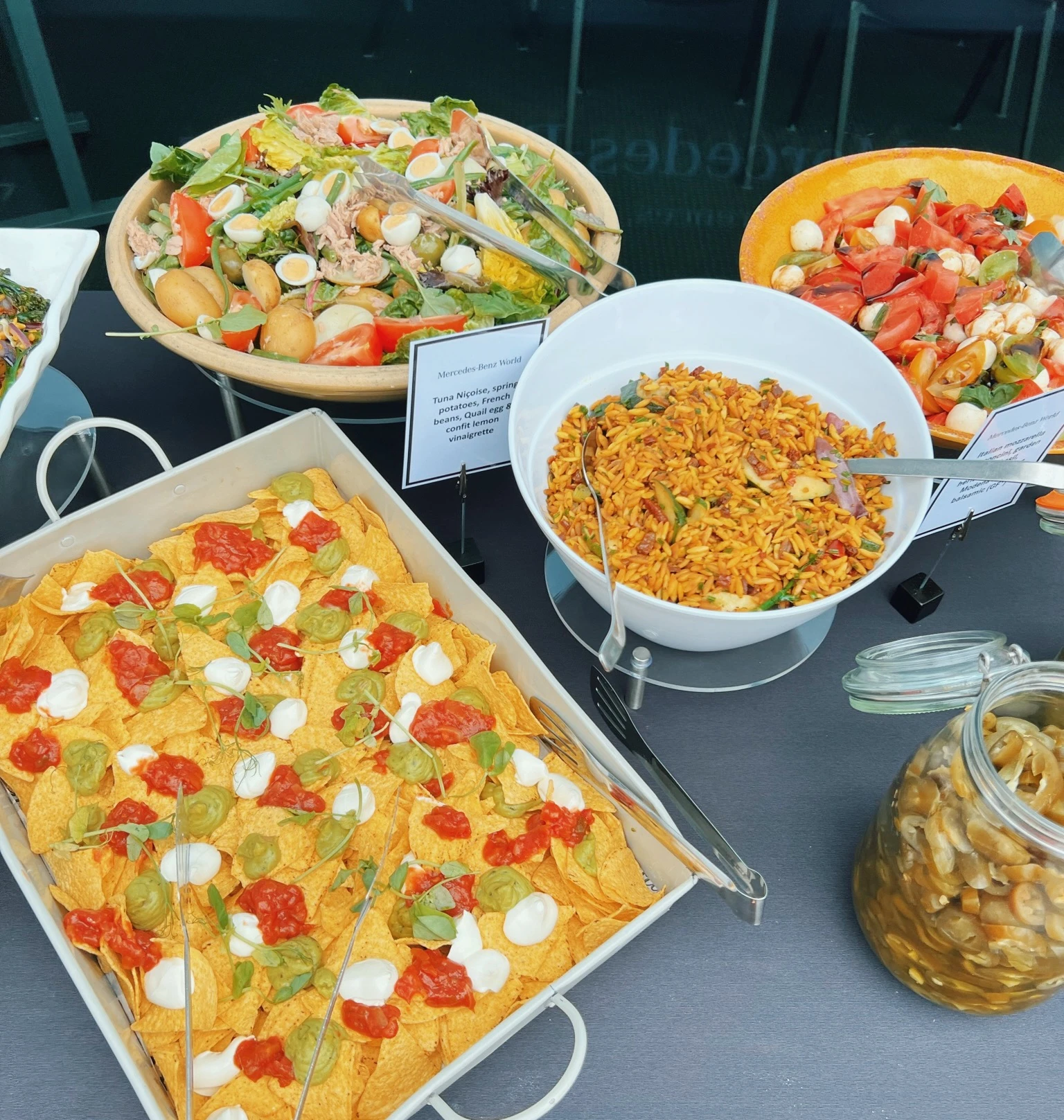 Buffet table with salads, nachos, rice and pickled vegetables at Mercedes-Benz World