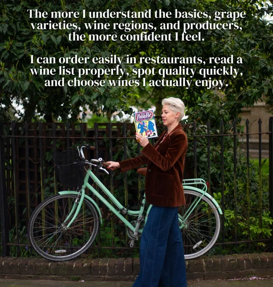 Woman in a brown jacket holding a wine magazine beside a mint-green bicycle